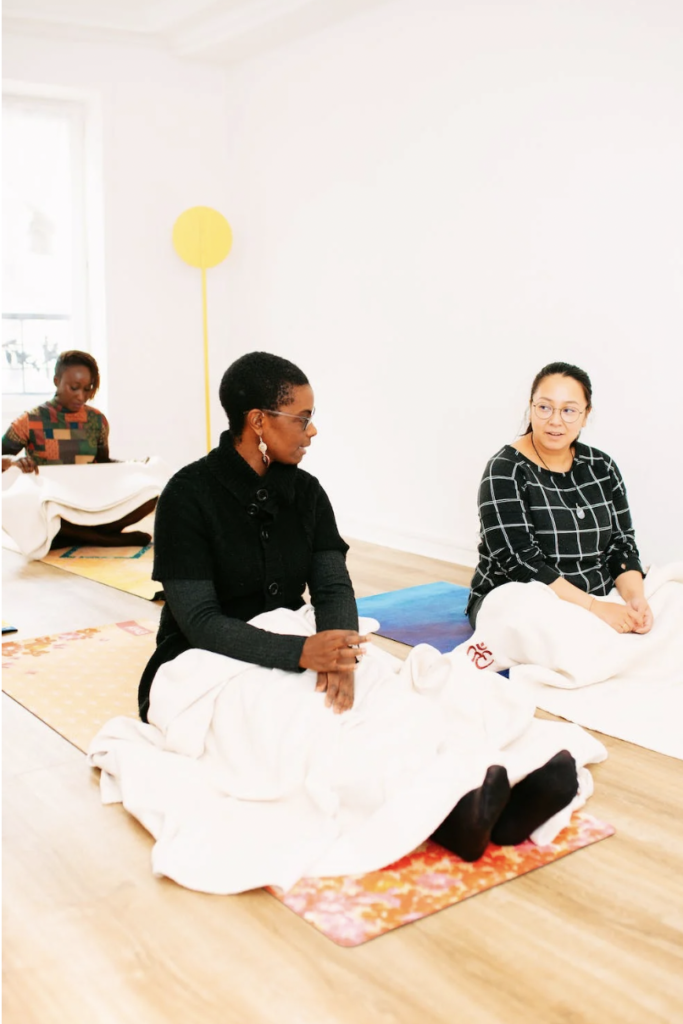 Types of Yoga: Yin Yoga, picture of women sitting on mats with blankets in a yoga studio